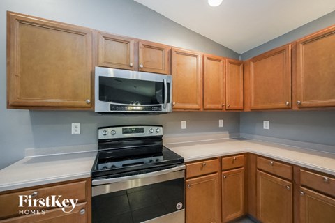 a kitchen with a stove and microwave and wooden cabinets