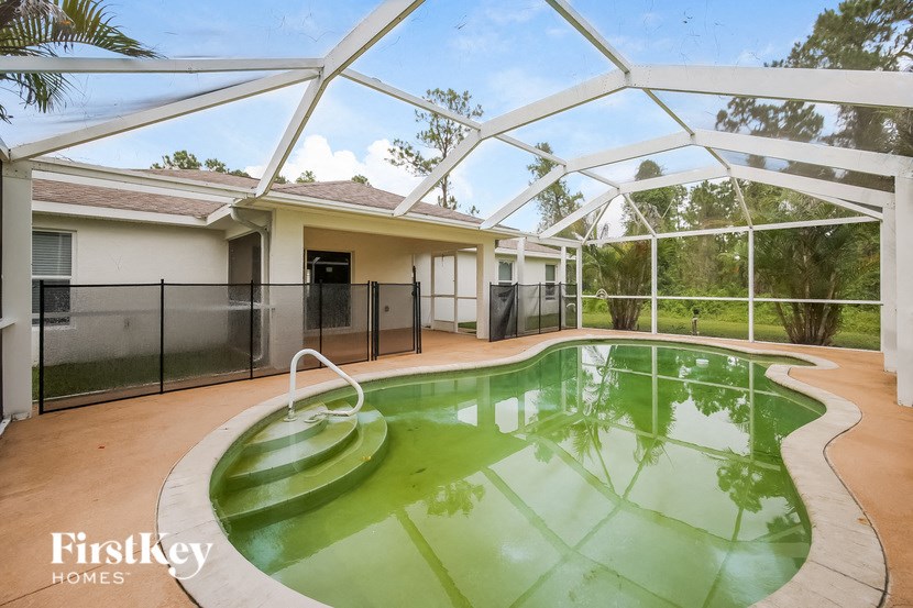a swimming pool with a house in the background