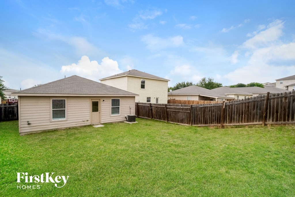 A house with a fence and a grassy yard is for sale.