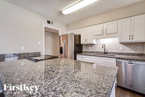 A kitchen with granite countertops and stainless steel appliances.