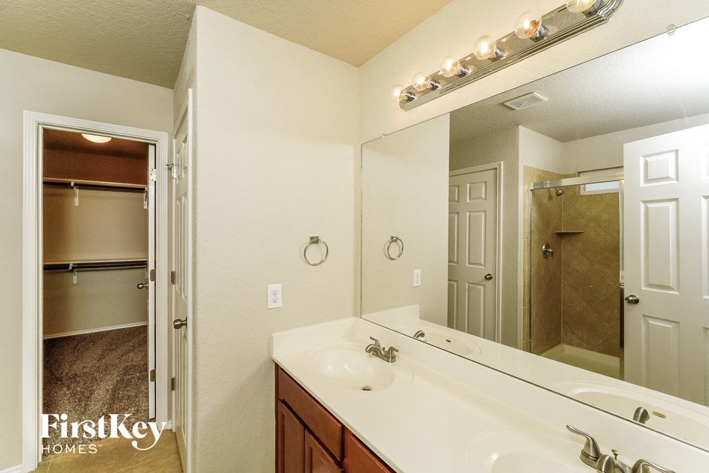 a bathroom with a sink and a mirror and a shower