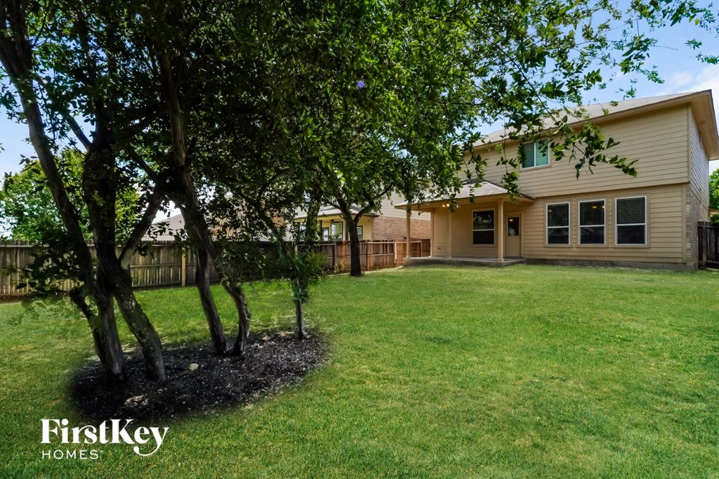 a backyard with trees and a house in the background