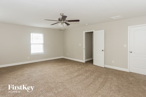 a living room with carpet and a ceiling fan