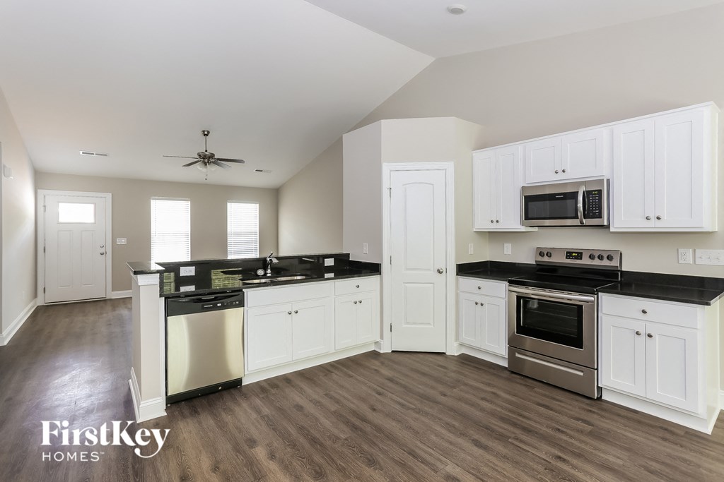 a kitchen with white cabinets and stainless steel appliances