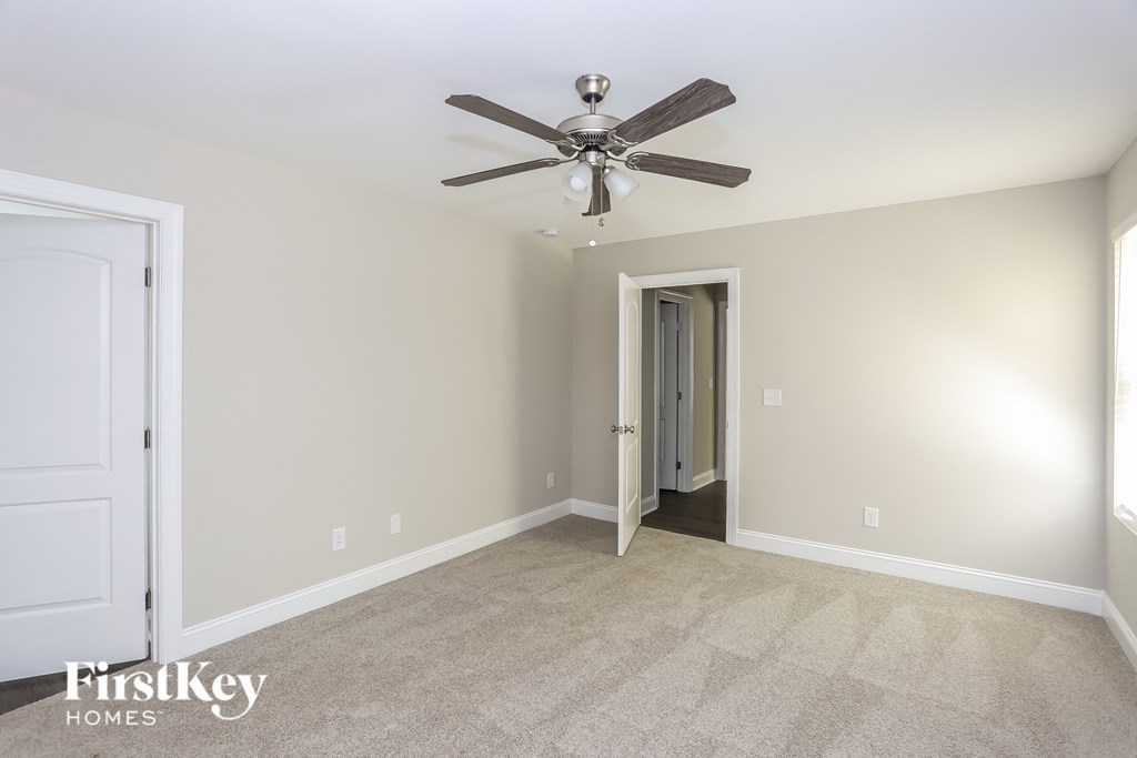 the master bedroom has a ceiling fan and carpeted flooring