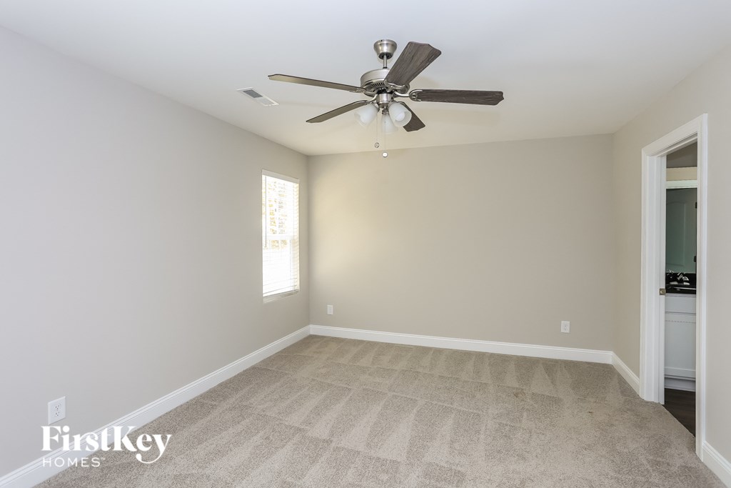 an empty room with a ceiling fan and a door to a closet