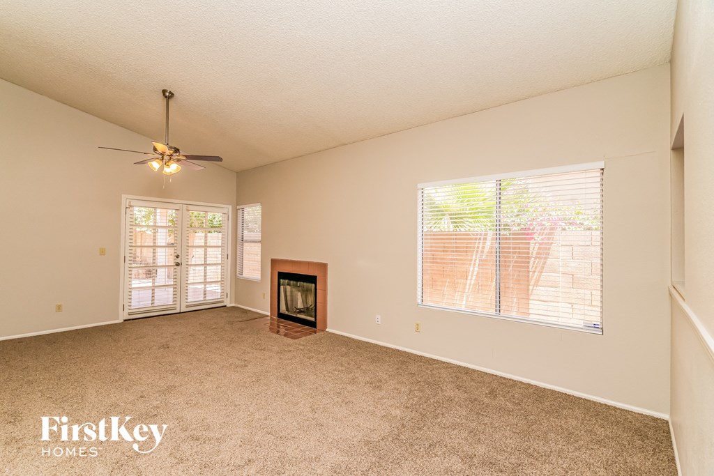 an empty living room with a fireplace and a window