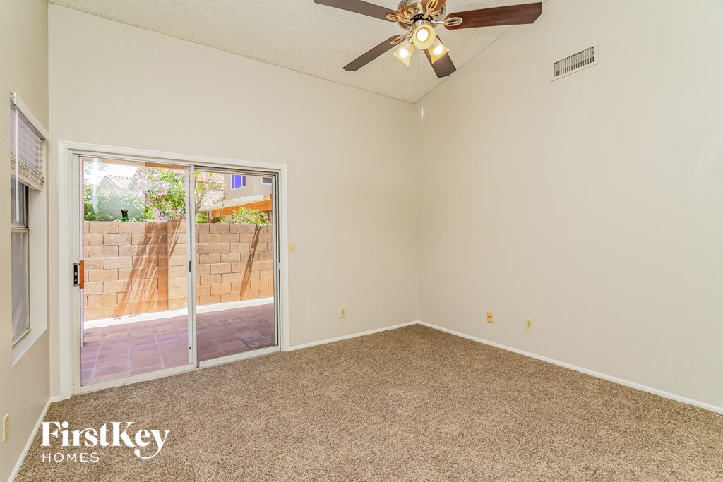 the living room of an empty house with a ceiling fan