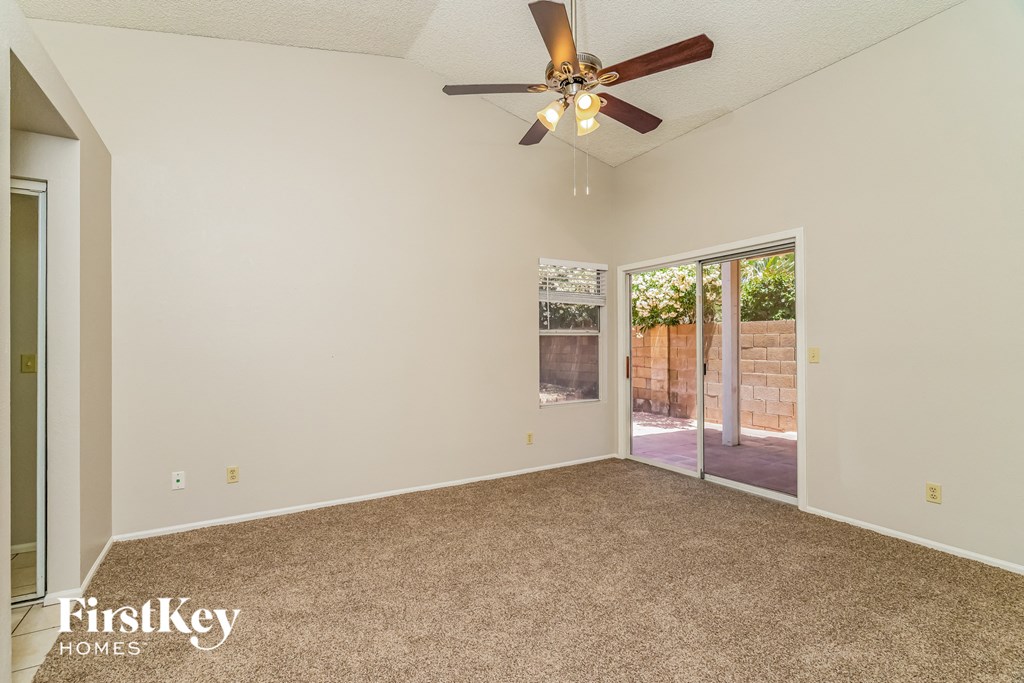 the living room of an empty house with a ceiling fan