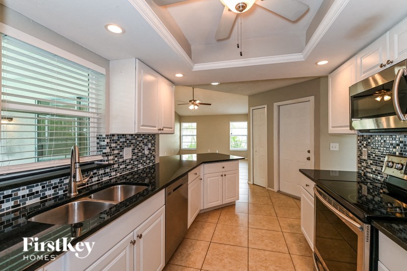 a kitchen with black counter tops and white cabinets and a sink