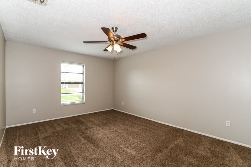 a living room with carpet and a ceiling fan