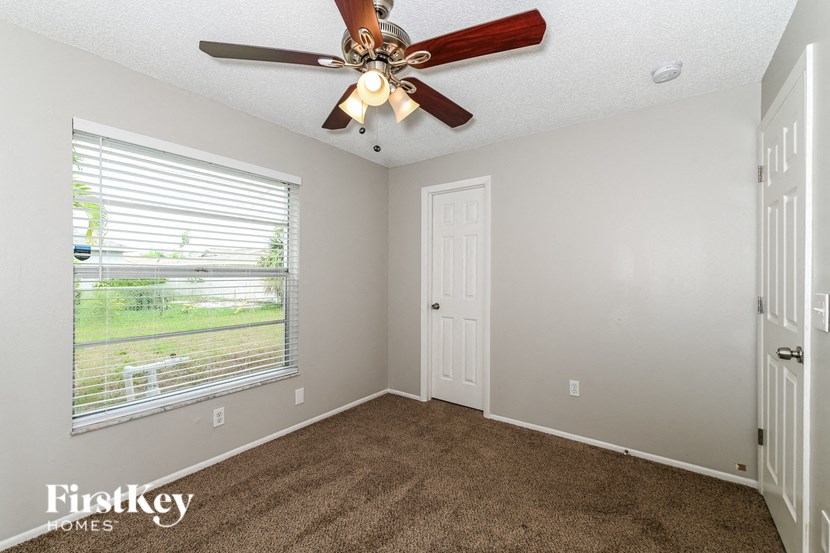 the living room has a ceiling fan and a large window