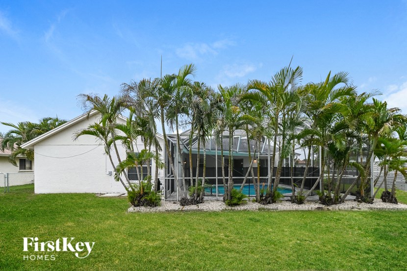 a home with palm trees in front of a glass house