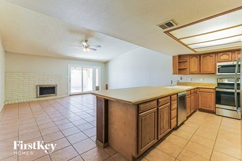 A kitchen with wooden cabinets and a tiled floor.