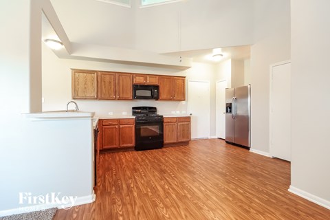 A kitchen with wooden cabinets and a stainless steel refrigerator.
