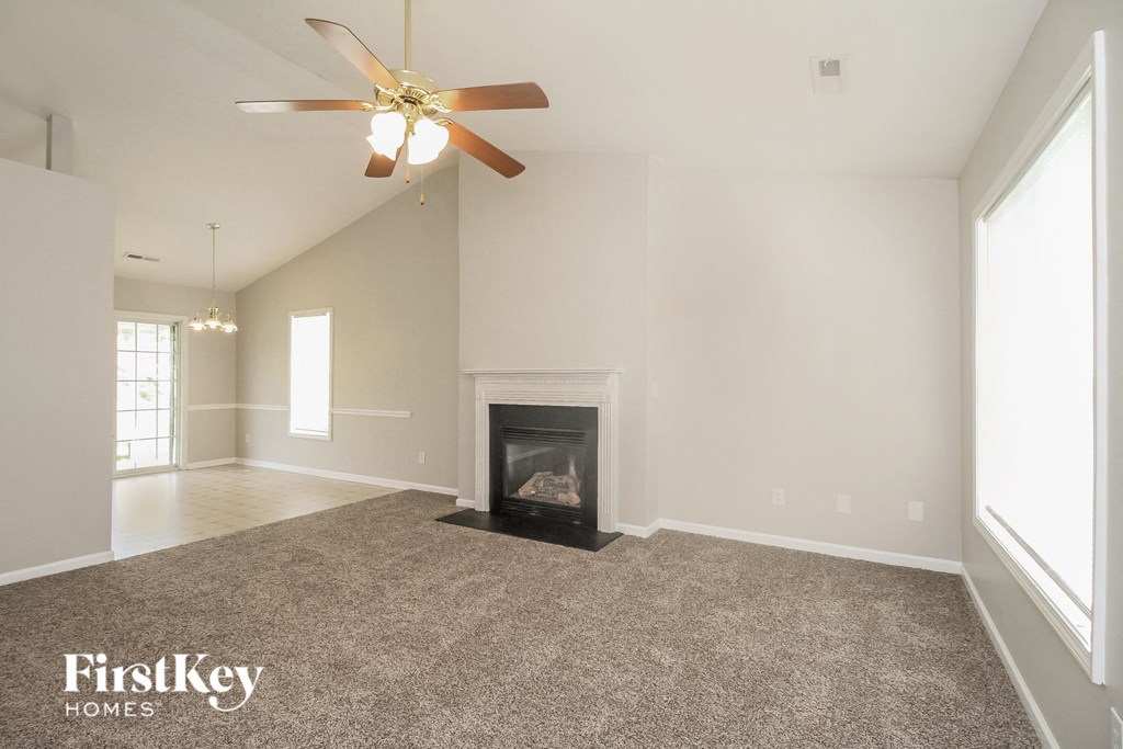 a living room with a fireplace and a ceiling fan