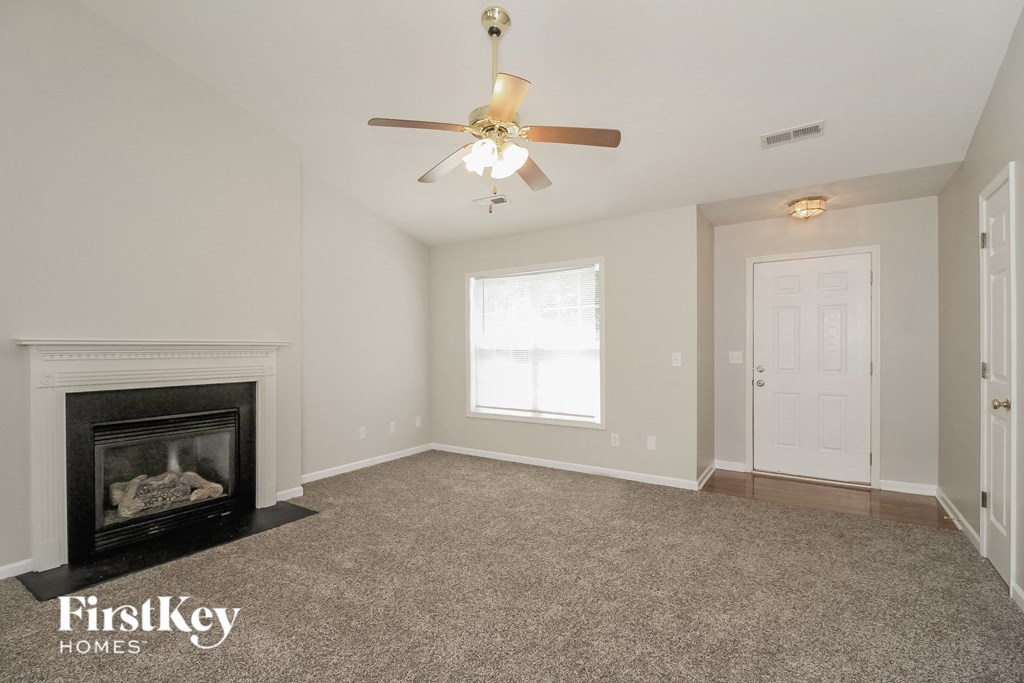 a living room with a fireplace and a ceiling fan
