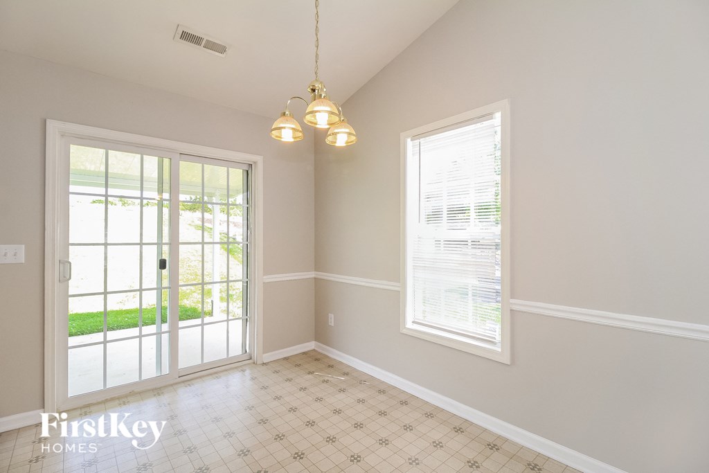 an empty dining room with a door to the backyard