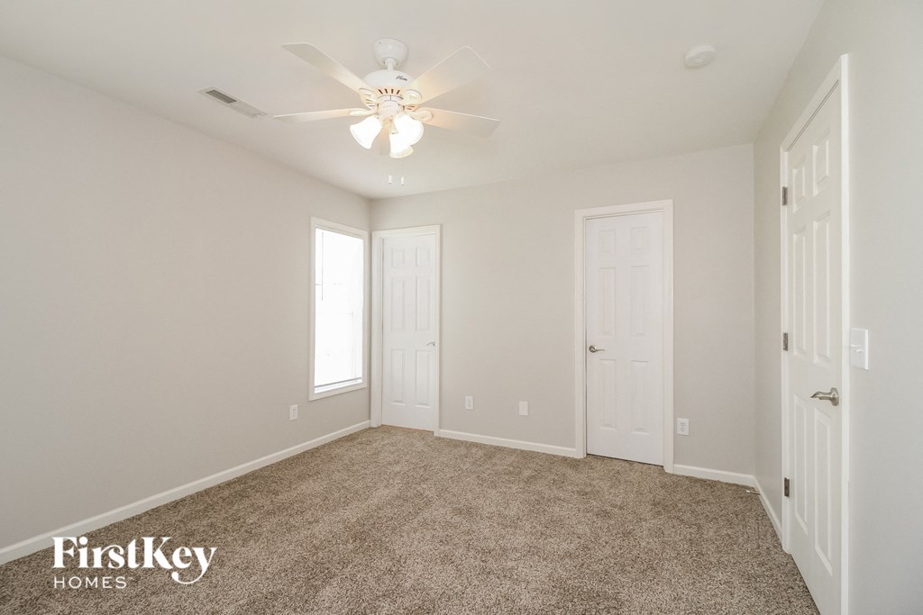a bedroom with carpet and a ceiling fan