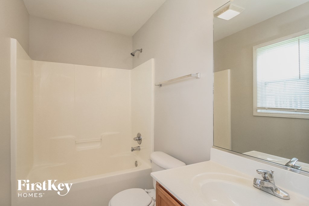 a bathroom with a sink toilet and tub and a mirror
