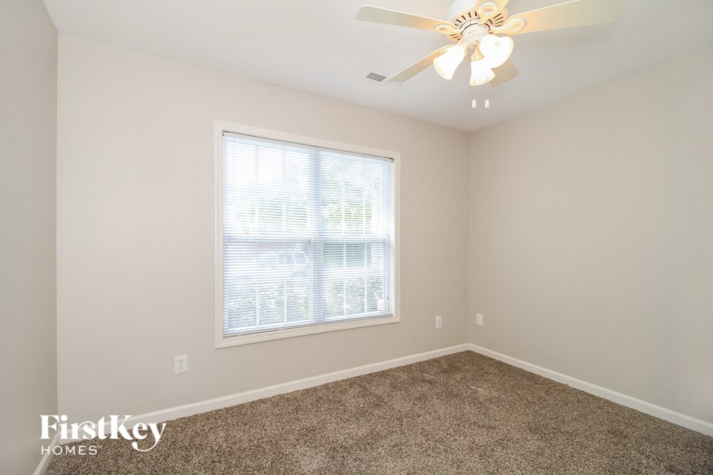a bedroom with a ceiling fan and a window
