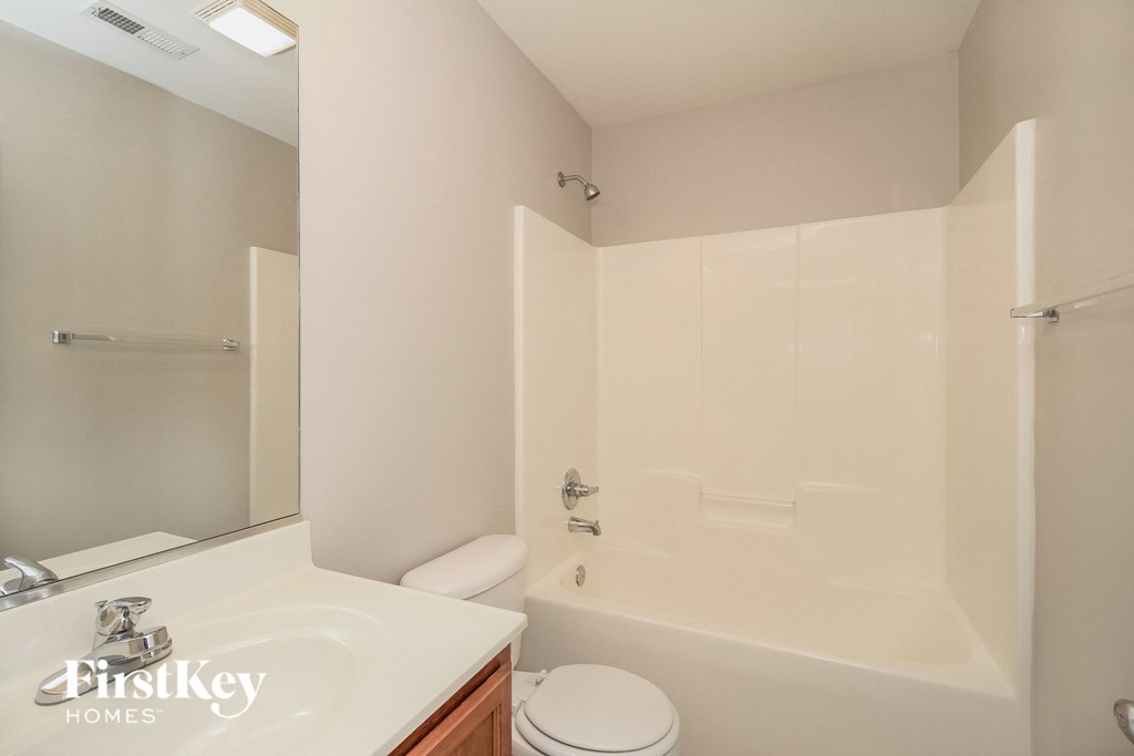 a bathroom with a toilet and a tub and a sink