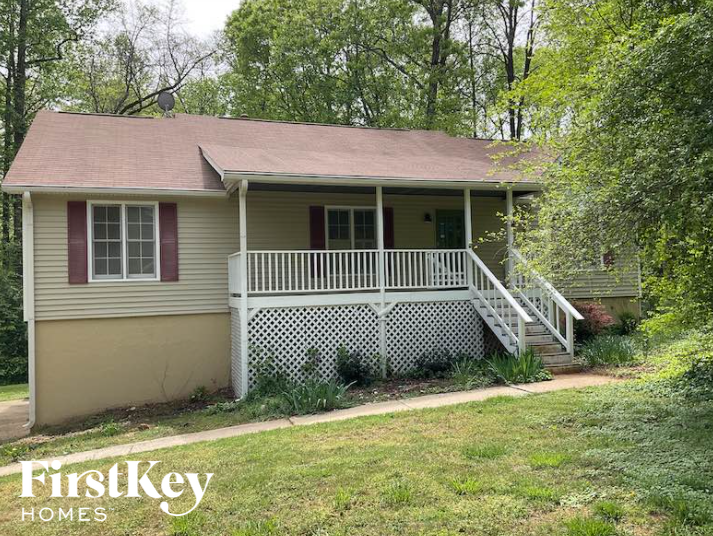 a small white house with a porch and a lawn