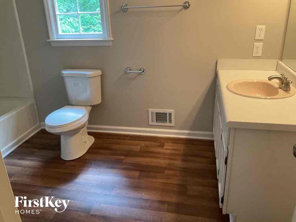 a bathroom with a toilet and a sink and a window
