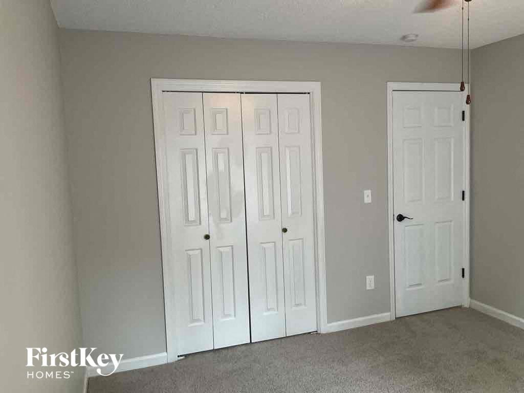 a bedroom with two closet doors and a carpeted floor