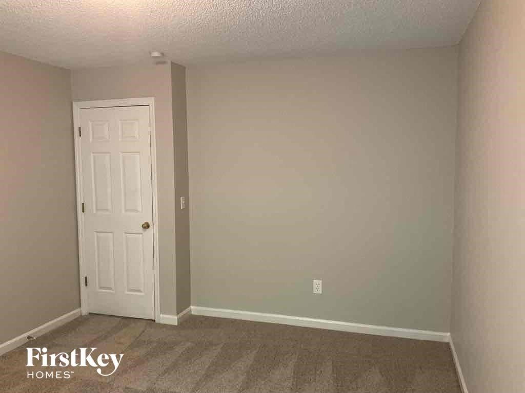 a bedroom with a white door and a carpeted floor