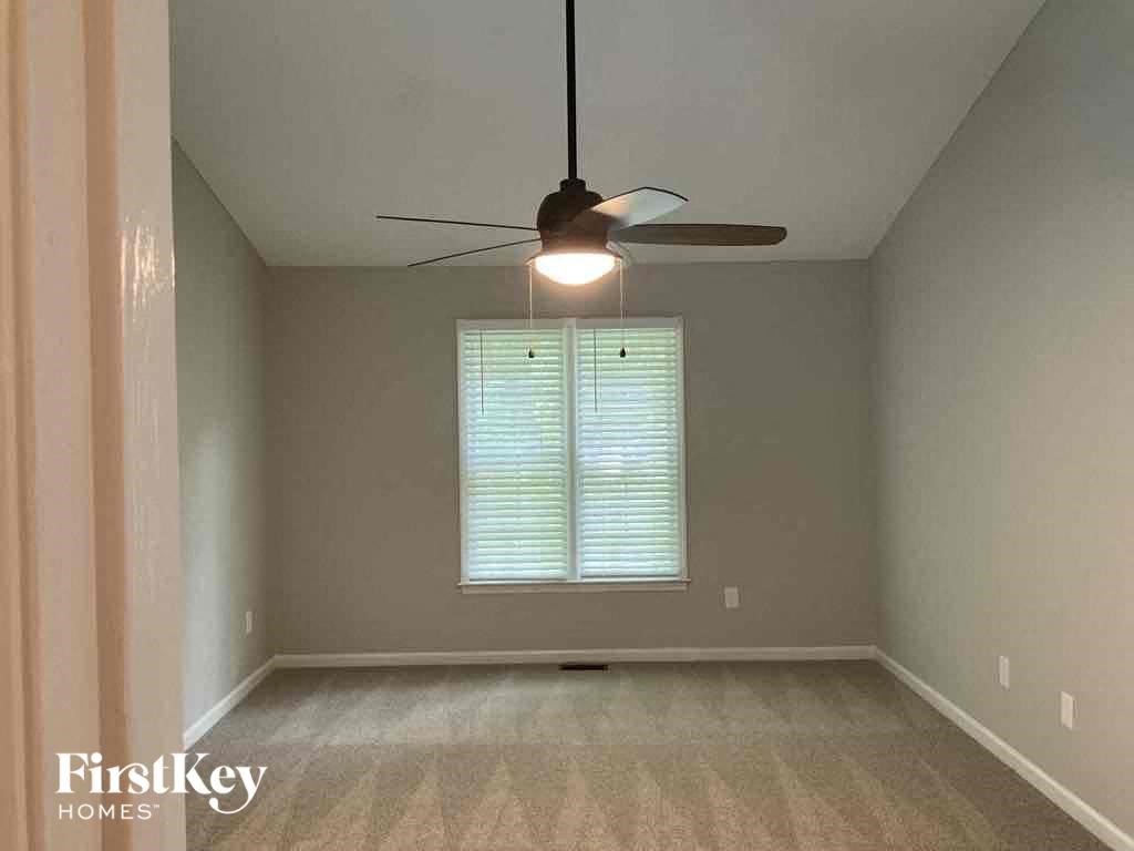 an empty room with a ceiling fan and a window