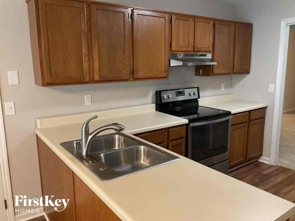 an empty kitchen with wooden cabinets and a sink
