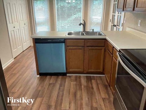 a kitchen with wooden floors and a dishwasher and sink