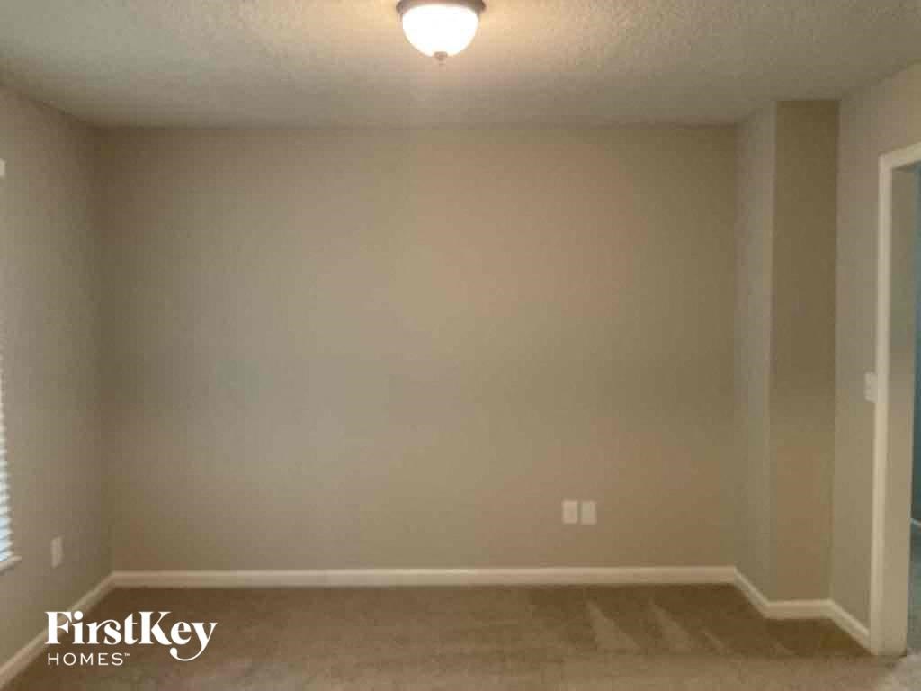 an empty living room with a light on the ceiling