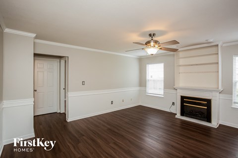 A room with a fireplace and a ceiling fan.