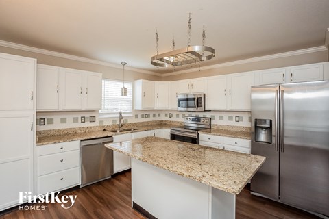 A kitchen with granite countertops and stainless steel appliances.