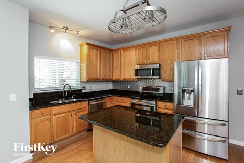 a kitchen with black granite counter tops and wooden cabinets