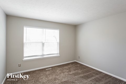 a bedroom with carpet and a window