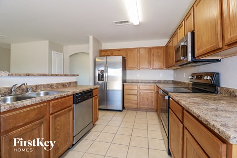 a kitchen with wooden cabinets and stainless steel appliances and granite counter tops