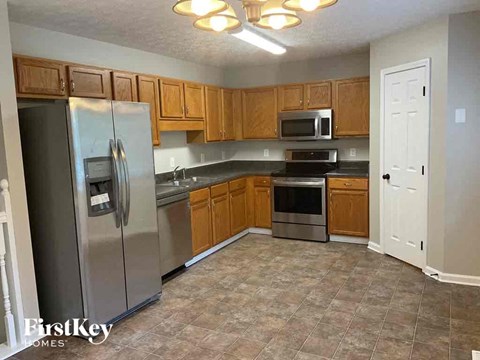 A kitchen with a refrigerator, oven, microwave, and stove.