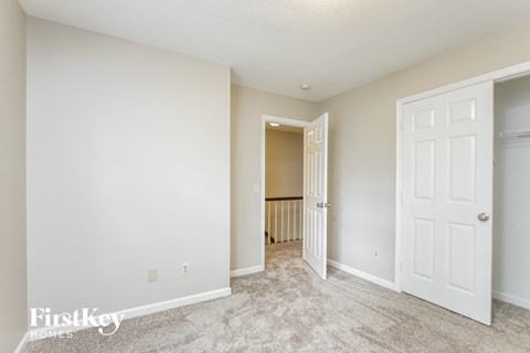 a bedroom with a closet and a door to a hallway