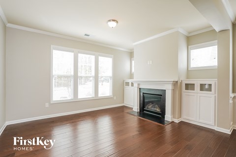 A spacious living room with a fireplace and wood flooring.