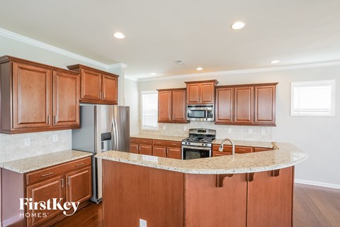 A kitchen with wooden cabinets and a marble countertop.