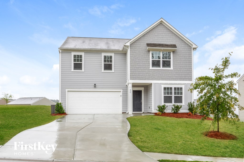a blue house with a white garage door and a green lawn