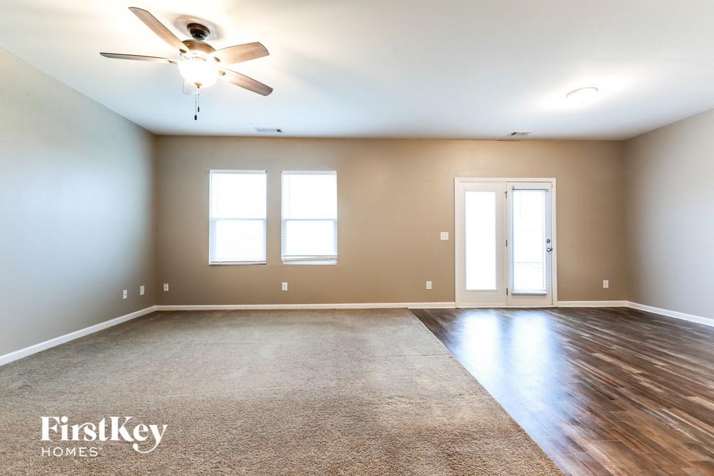 the master bedroom is spacious and has a ceiling fan and hardwood floors