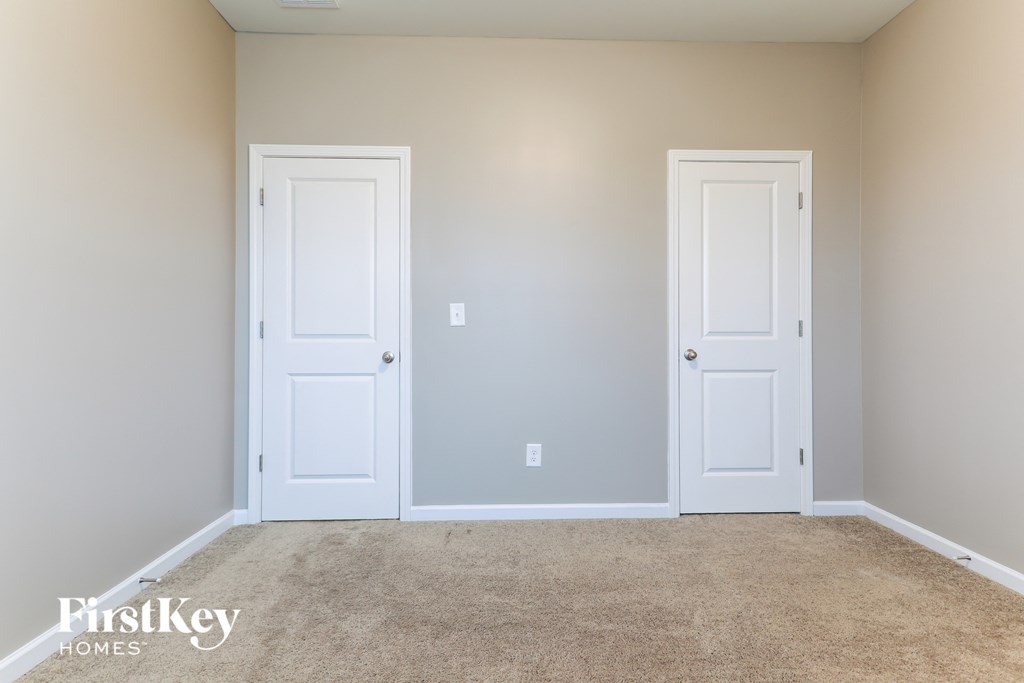 a room with two white doors and a carpeted floor