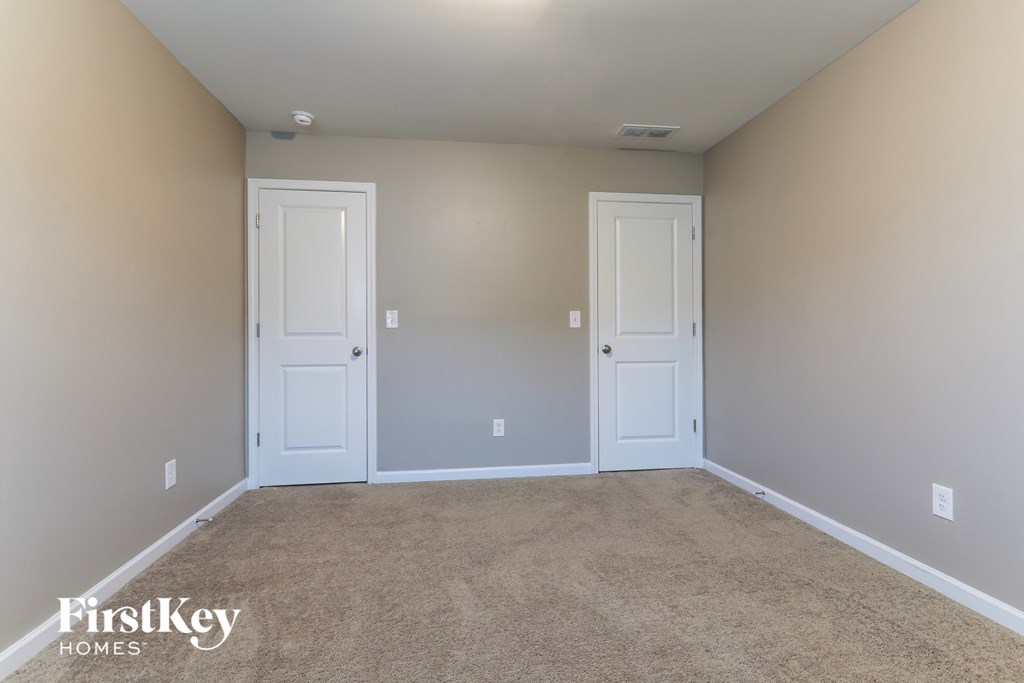 a empty room with two doors and a carpeted floor