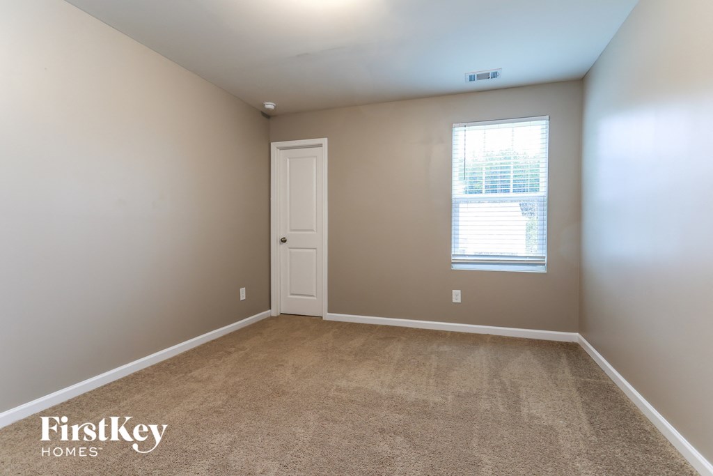 a bedroom with a carpeted floor and a window