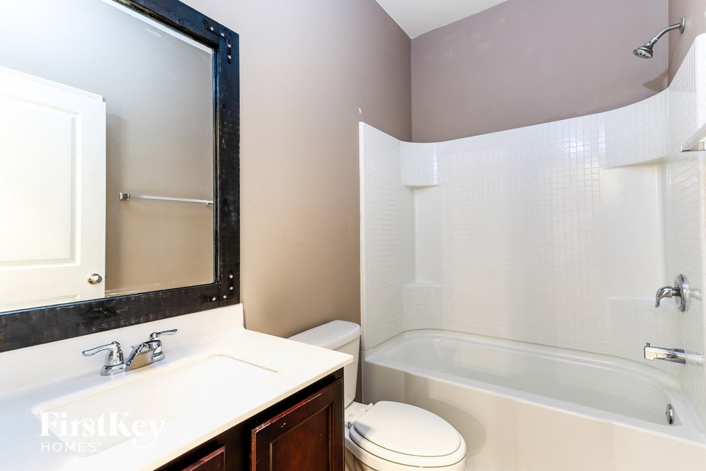 a bathroom with a sink toilet and tub and a mirror