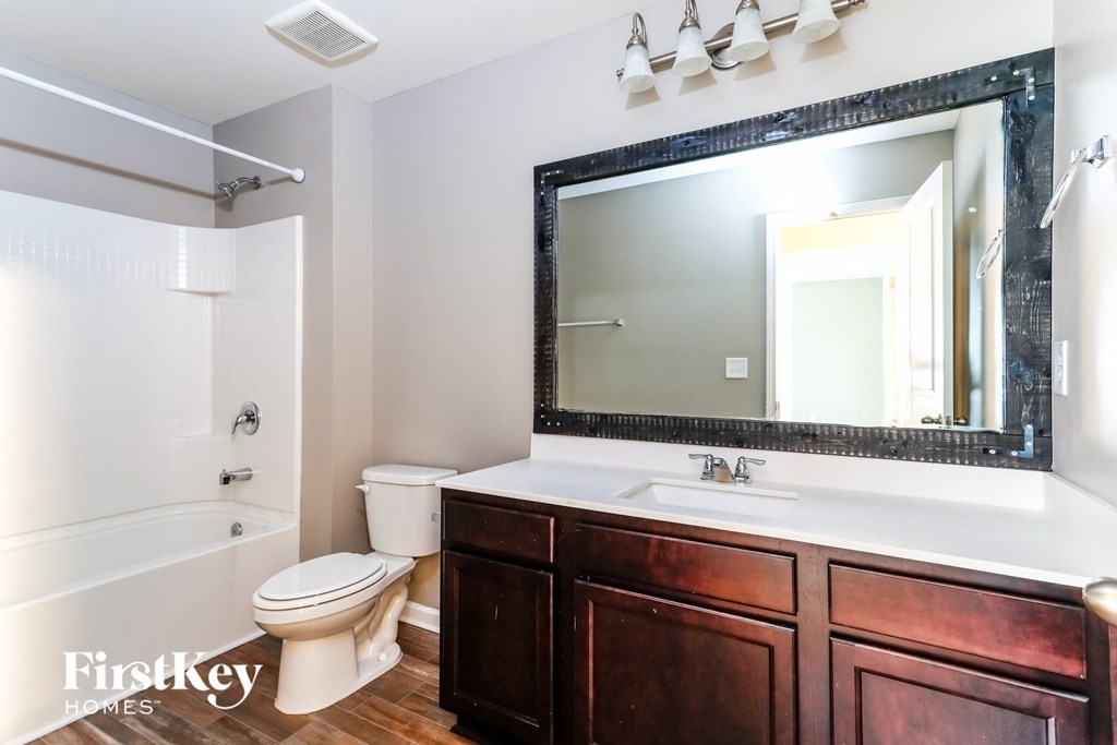 a bathroom with a toilet and a sink and a mirror